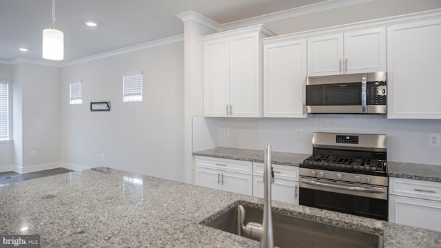 kitchen featuring light stone counters, backsplash, appliances with stainless steel finishes, ornamental molding, and a sink