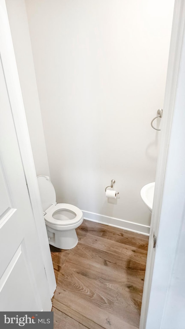 bathroom featuring wood finished floors, toilet, and baseboards