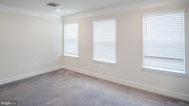 unfurnished room featuring carpet floors, a healthy amount of sunlight, visible vents, and baseboards