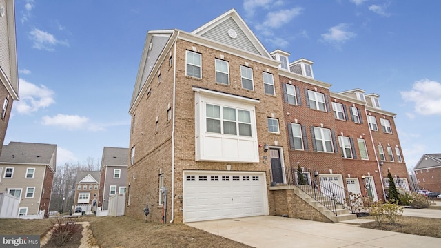 multi unit property featuring concrete driveway, brick siding, and an attached garage