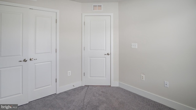 unfurnished bedroom featuring carpet floors, baseboards, and visible vents