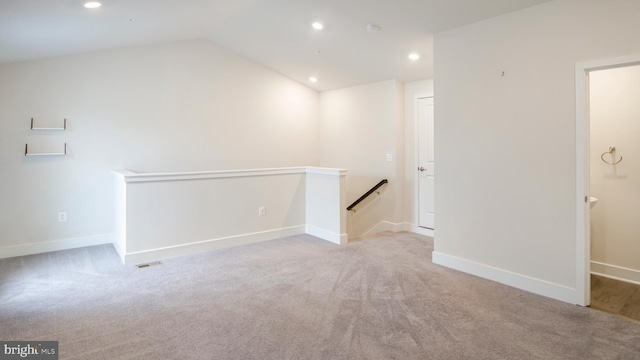 carpeted empty room featuring lofted ceiling, baseboards, and recessed lighting