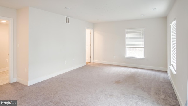 carpeted empty room with baseboards and visible vents