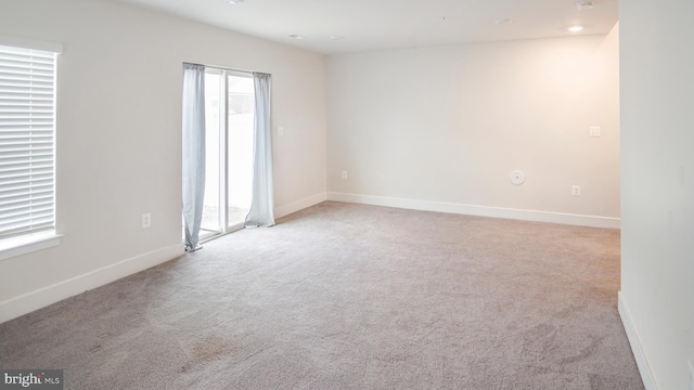 carpeted empty room featuring recessed lighting and baseboards