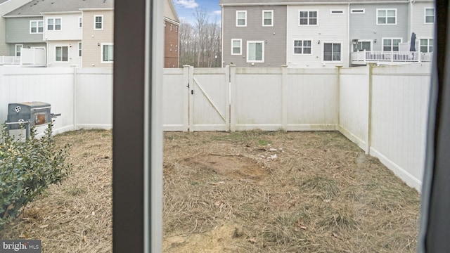 view of yard featuring a fenced backyard and a gate