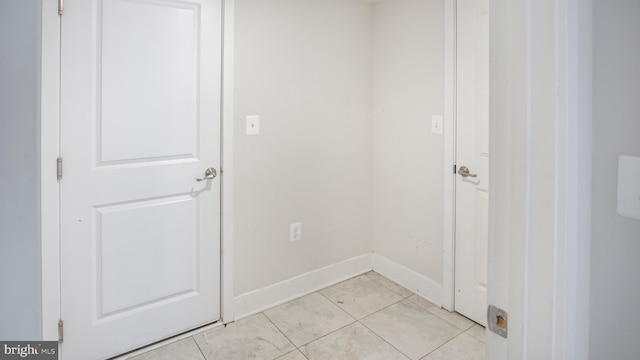 interior space with baseboards and light tile patterned flooring