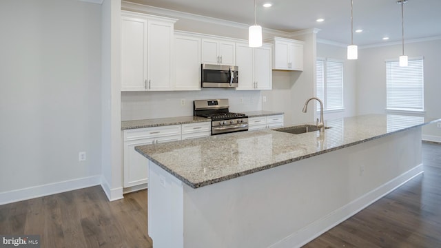 kitchen featuring dark wood-style floors, stainless steel appliances, ornamental molding, white cabinets, and a sink