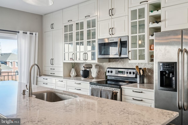 kitchen with a sink, tasteful backsplash, appliances with stainless steel finishes, and white cabinetry