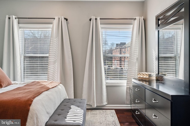 bedroom with dark wood finished floors, multiple windows, and baseboards