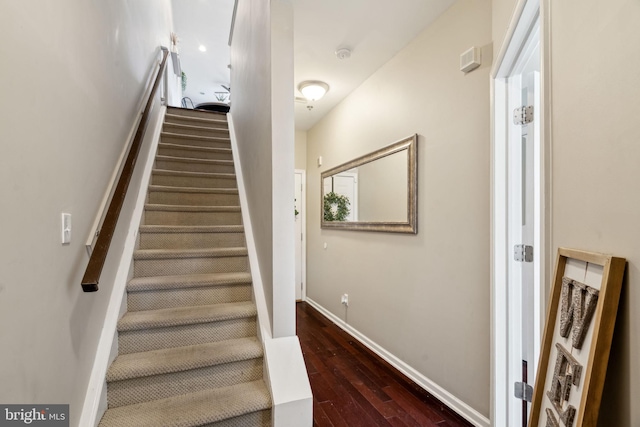 staircase featuring baseboards and hardwood / wood-style floors