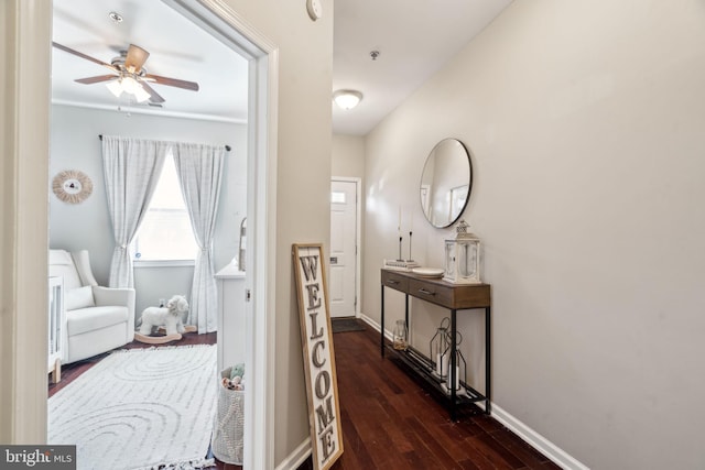 corridor with dark wood-type flooring and baseboards