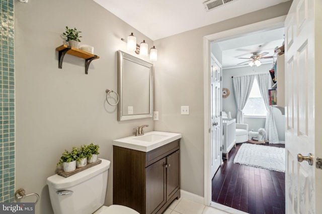 bathroom with visible vents, toilet, a ceiling fan, baseboards, and vanity