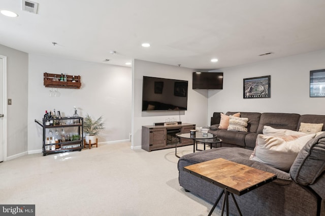 living area featuring recessed lighting, visible vents, baseboards, and light colored carpet