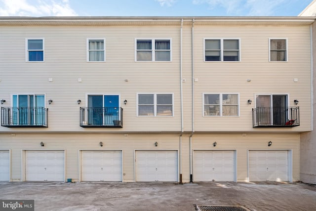 rear view of property featuring a garage and driveway