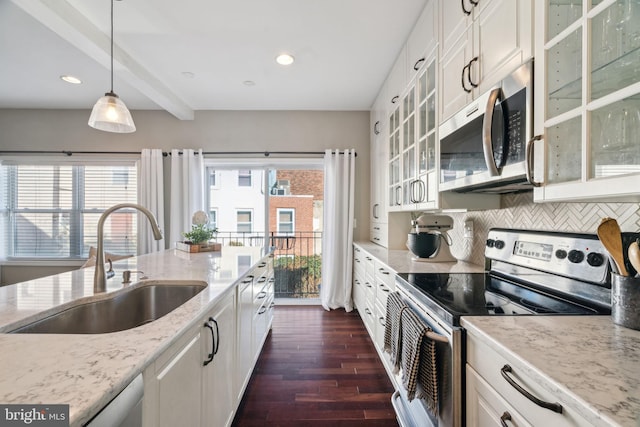 kitchen with a wealth of natural light, tasteful backsplash, appliances with stainless steel finishes, and a sink