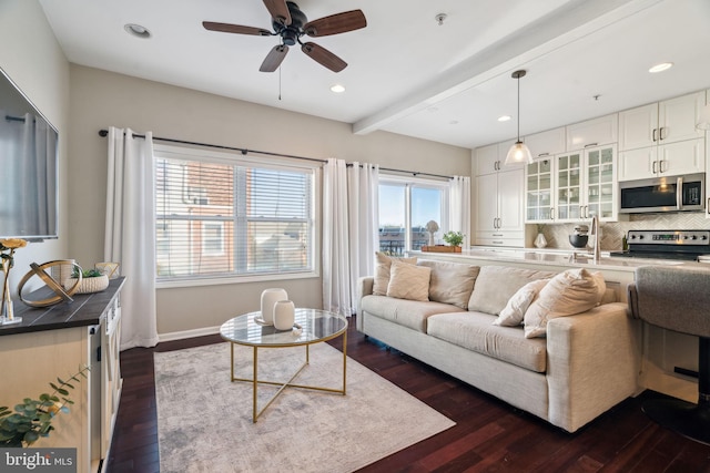 living room featuring baseboards, ceiling fan, dark wood finished floors, beamed ceiling, and recessed lighting