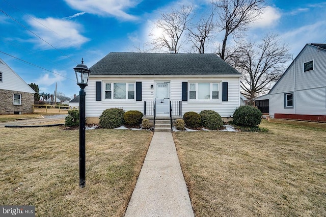 bungalow-style house with roof with shingles and a front yard