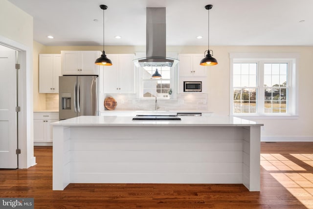 kitchen featuring hanging light fixtures, white cabinetry, island range hood, and stainless steel appliances