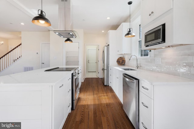 kitchen with pendant lighting, stainless steel appliances, visible vents, white cabinets, and a sink