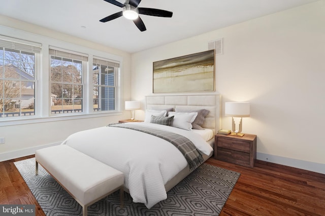 bedroom featuring dark wood-type flooring, visible vents, baseboards, and a ceiling fan