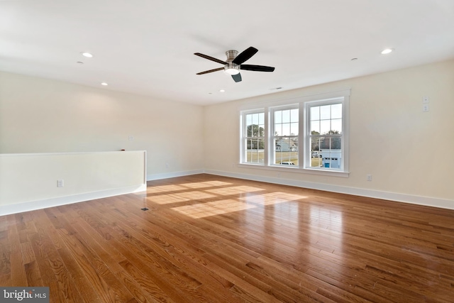 empty room featuring baseboards, wood finished floors, and recessed lighting