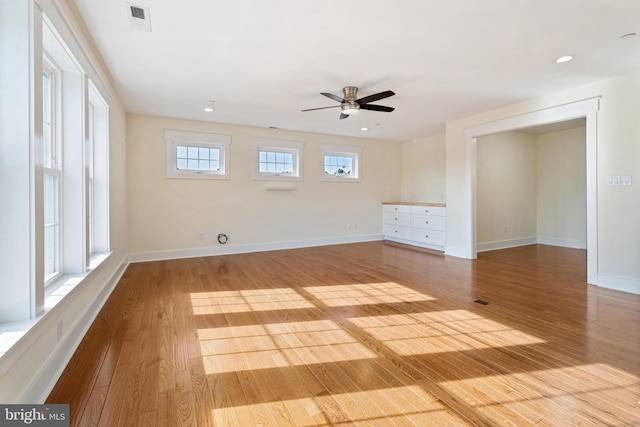 empty room featuring light wood-style floors, baseboards, and visible vents