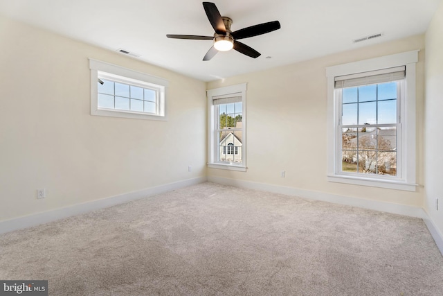 spare room featuring baseboards, visible vents, and light colored carpet