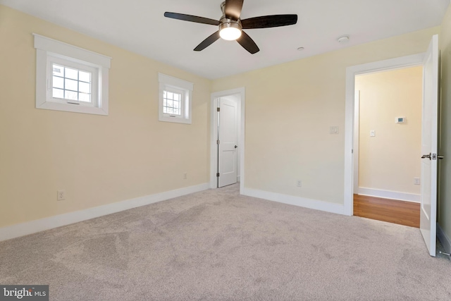 empty room featuring light colored carpet and baseboards