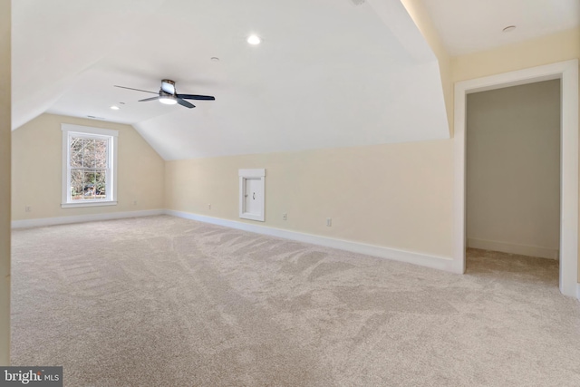 additional living space with recessed lighting, light colored carpet, vaulted ceiling, and baseboards