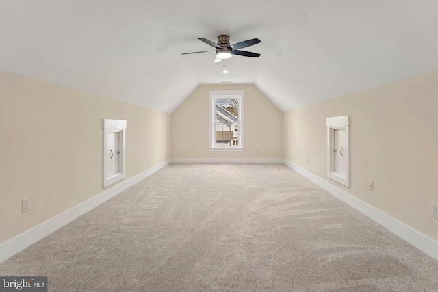 bonus room with vaulted ceiling, light carpet, and baseboards