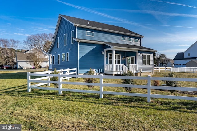 view of front of home with a fenced front yard, a front yard, and covered porch