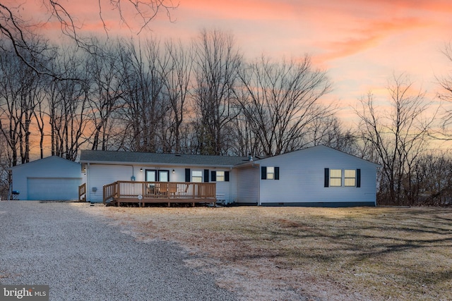 view of front of home with an outbuilding, a yard, a wooden deck, and a garage