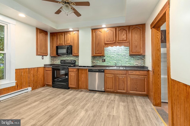 201 Washington St, Cambridge, MD 21613 - kitchen featuring black appliances, wainscoting, dark countertops, healthy amount of natural light, and brown cabinets