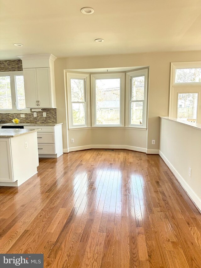 kitchen with light wood finished floors, white cabinetry, and a wealth of natural light