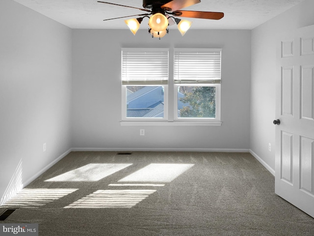 carpeted empty room featuring a textured ceiling, a ceiling fan, visible vents, and baseboards