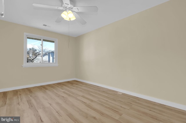 unfurnished room with light wood finished floors, visible vents, baseboards, and a ceiling fan