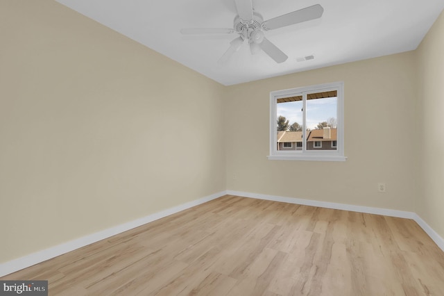 empty room with baseboards, a ceiling fan, visible vents, and light wood-style floors