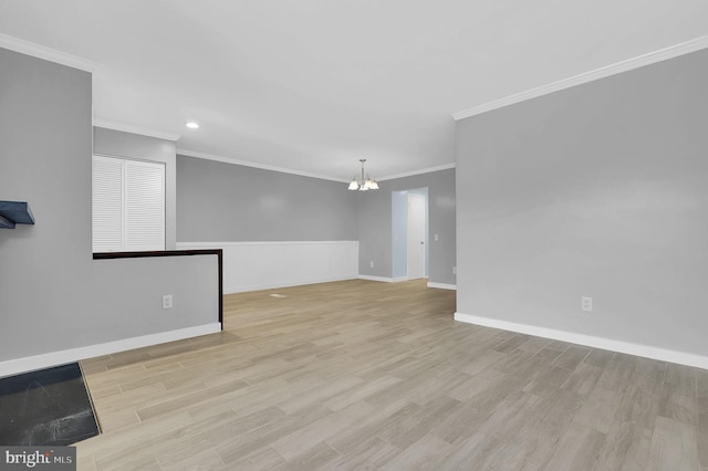 spare room with recessed lighting, a notable chandelier, wood finished floors, baseboards, and ornamental molding