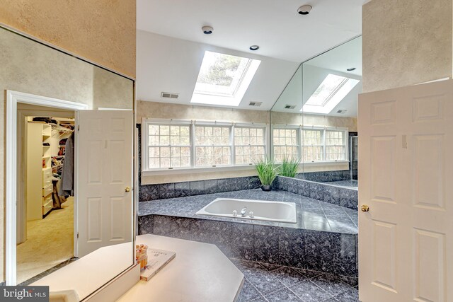 2 Wilderness Dr, Medford, NJ 08055 - bathroom with visible vents, plenty of natural light, a bath, and vaulted ceiling with skylight