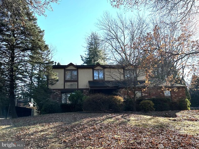 view of front of house featuring brick siding and stucco siding