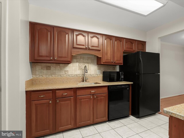 kitchen with light tile patterned floors, black appliances, a sink, and decorative backsplash