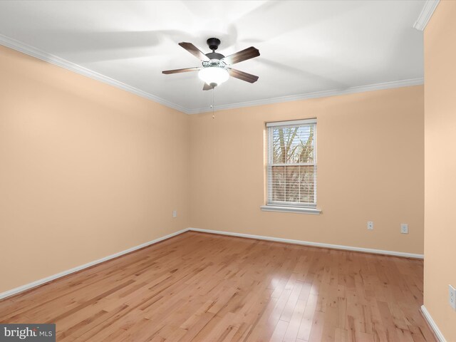 spare room with baseboards, light wood finished floors, a ceiling fan, and crown molding