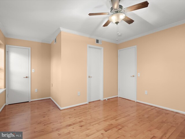 spare room featuring a ceiling fan, baseboards, visible vents, light wood-style floors, and ornamental molding