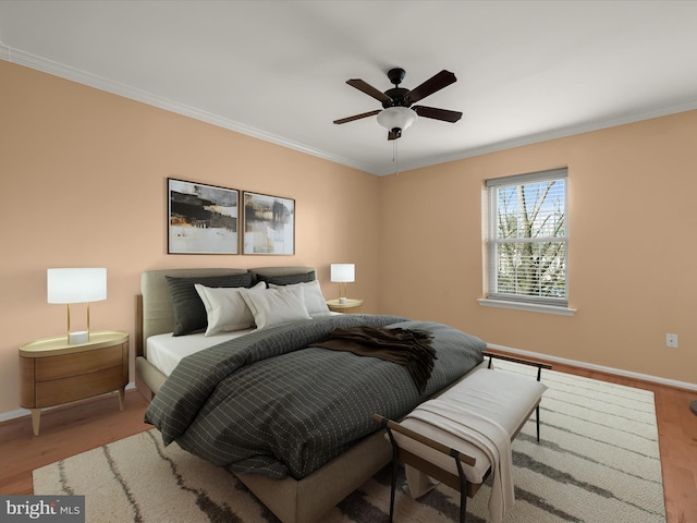 bedroom with light wood-type flooring, baseboards, and crown molding