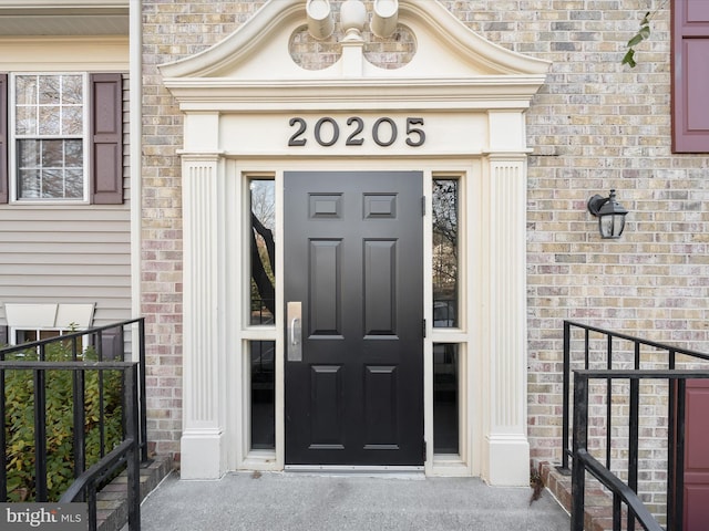 property entrance featuring brick siding