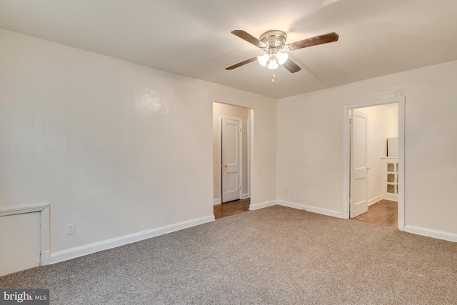 empty room featuring a ceiling fan, light colored carpet, and baseboards