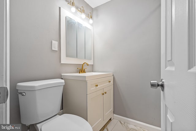 half bathroom featuring vanity, toilet, baseboards, and marble finish floor