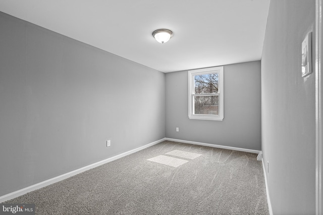 unfurnished room with baseboards and carpet floors