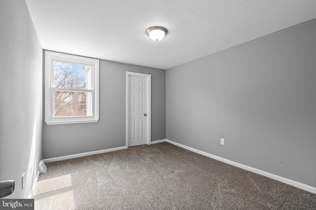 spare room with baseboards and carpet