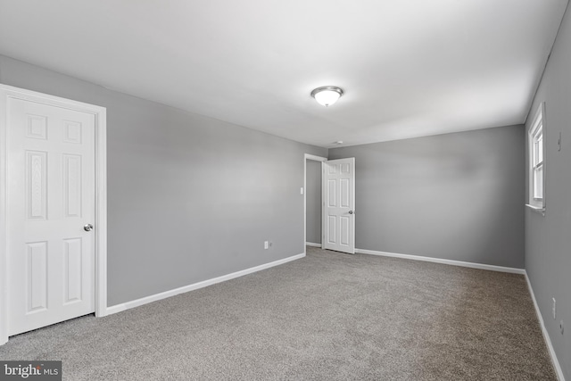 carpeted empty room with baseboards